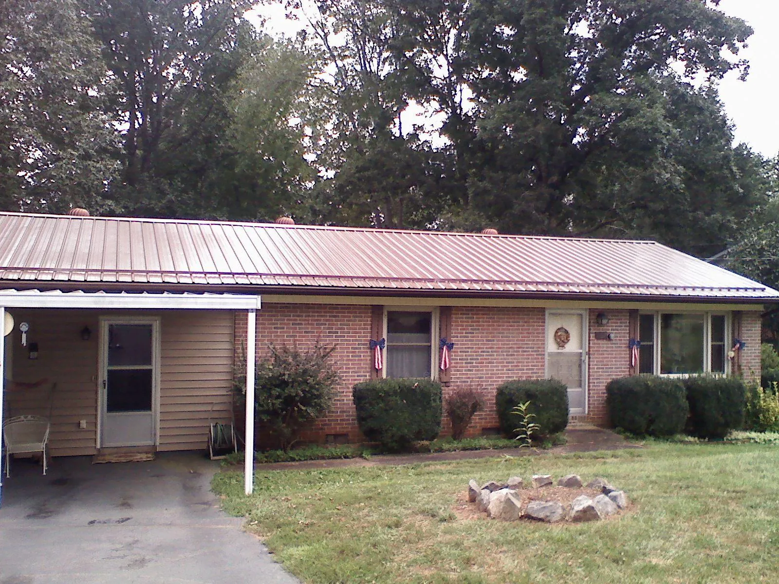 Bronze metal roof and carport on a brick ranch home — Roof Repair work by our crew in Leitchfield